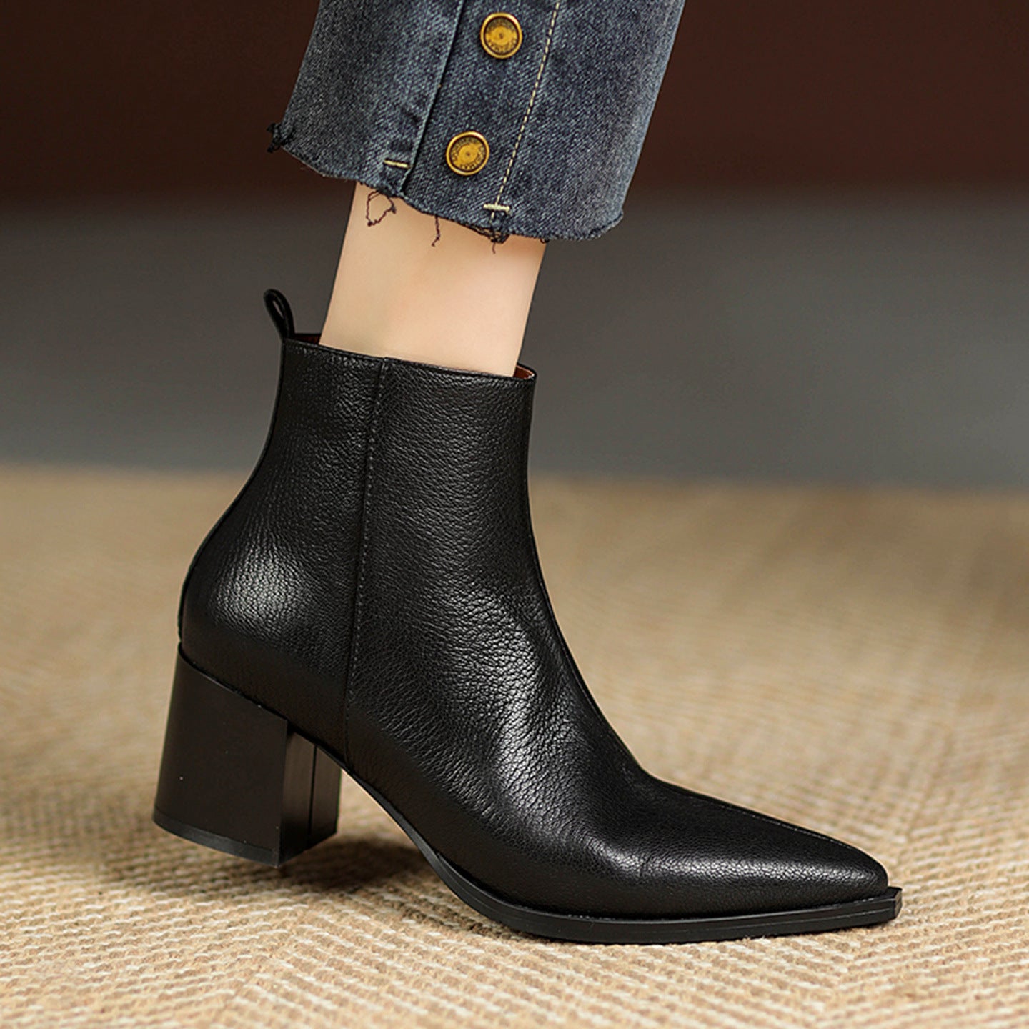 Black leather ankle boot on a neutral background