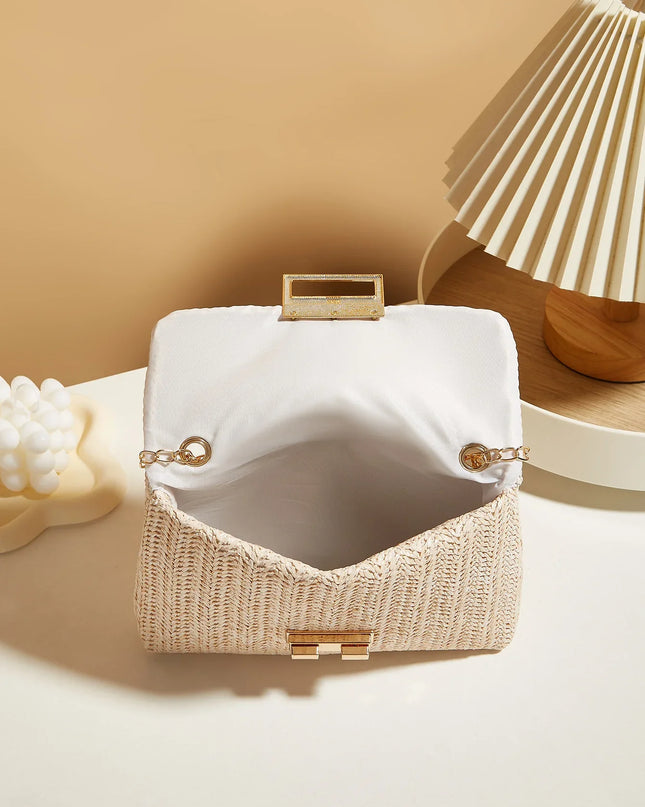 White handbag with gold accents on a beige surface