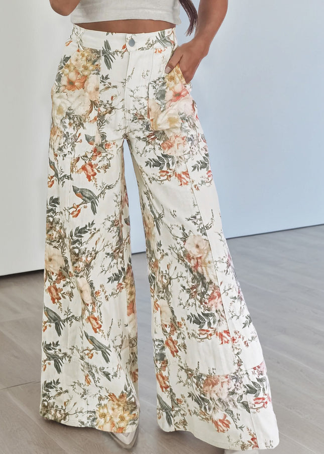 Floral patterned pants worn by a person on a neutral background