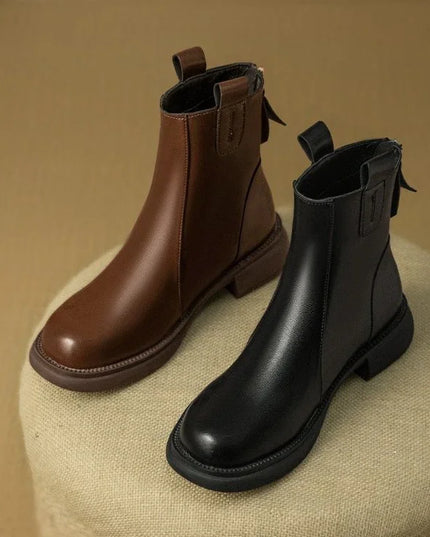 Brown and black leather boots on a textured surface