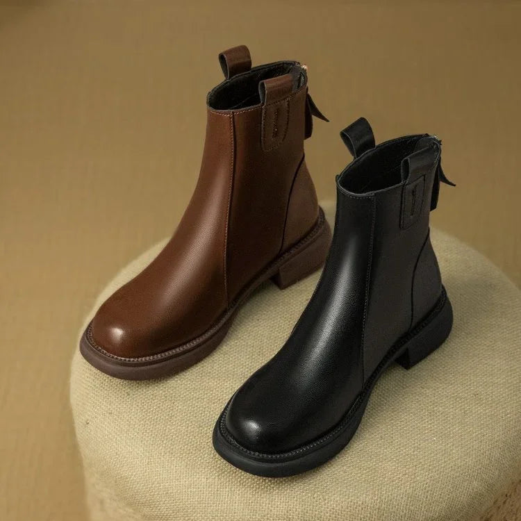 Brown and black leather boots on a textured surface