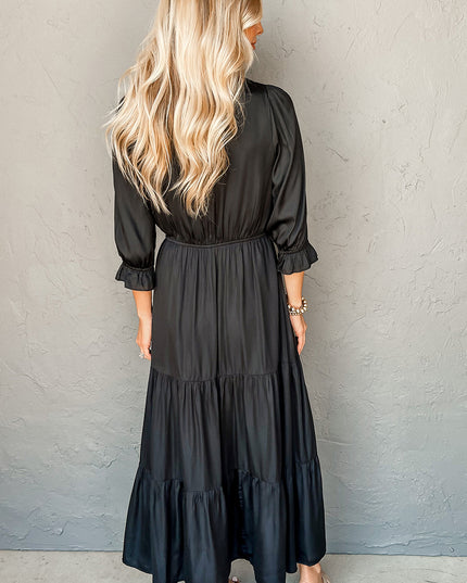 Woman wearing a black dress against a gray wall
