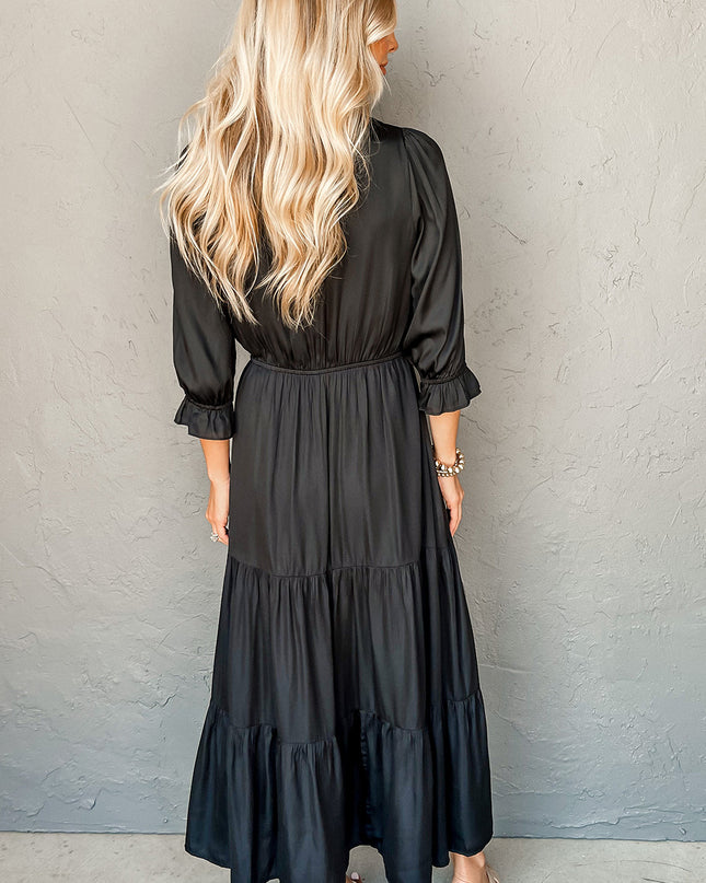 Woman wearing a black dress against a gray wall