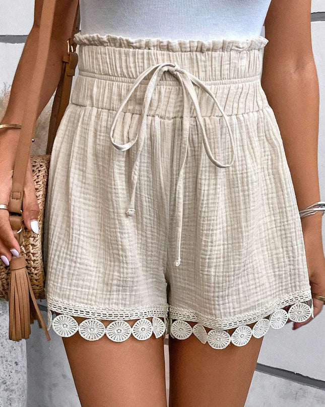 Beige shorts with lace trim worn by a person, against a neutral background