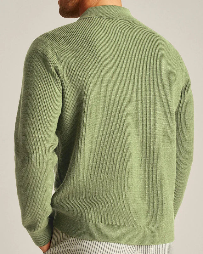 Green sweater worn by a person on a plain background