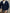 Person wearing a navy blue cable knit cardigan holding a Louis Vuitton handbag.