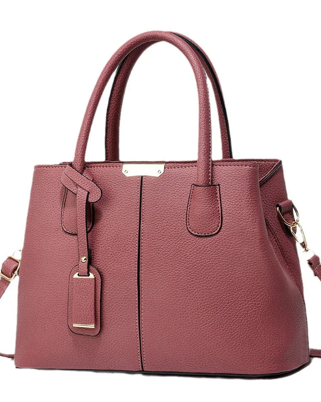 Pink handbag with gold accents on a white background