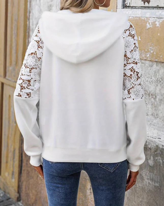 White hoodie with lace sleeves worn by a person against a textured wall.