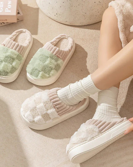 White fuzzy slippers with green interior on a light wooden floor.