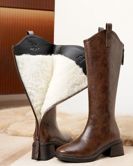 Brown knee-high boots with white fur lining on a soft surface.