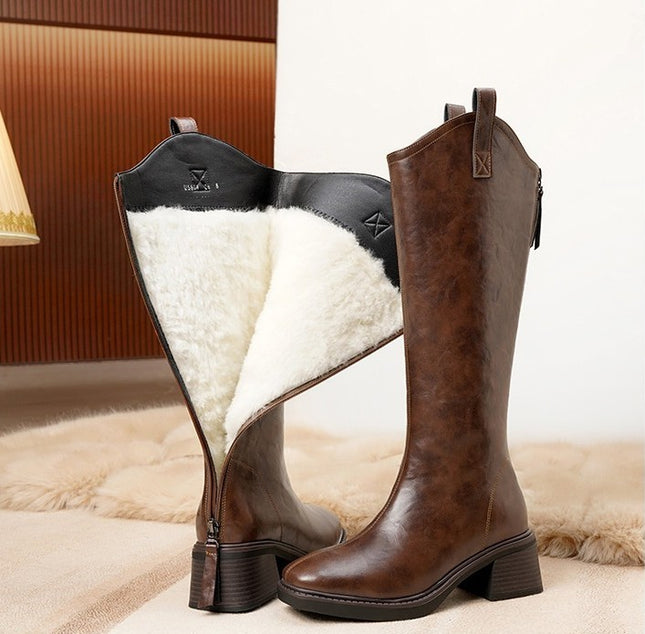 Brown knee-high boots with white fur lining on a soft surface.