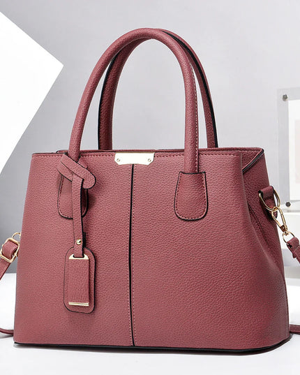 Pink handbag with gold accents on a white background