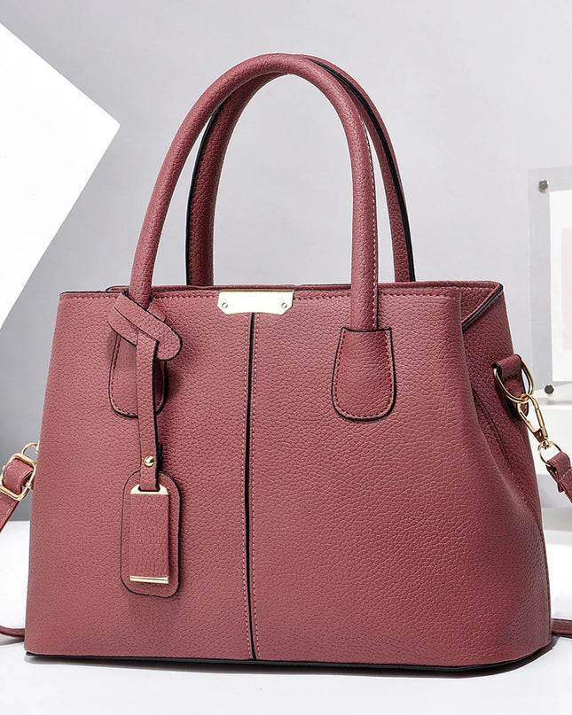 Pink handbag with gold accents on a white background