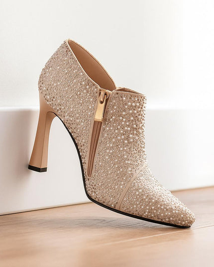 Sparkly high-heeled shoe on a light wooden floor with a white wall background