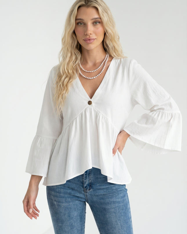 Woman wearing a white blouse and blue jeans against a white background