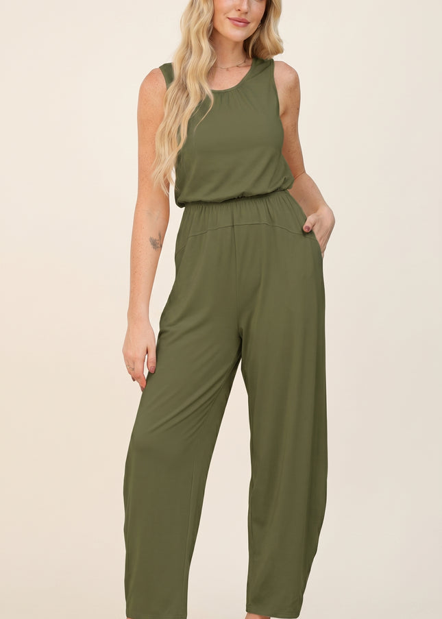 Woman wearing an olive green jumpsuit on a beige background