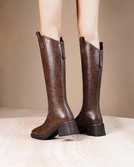 Brown knee-high boots on a neutral background