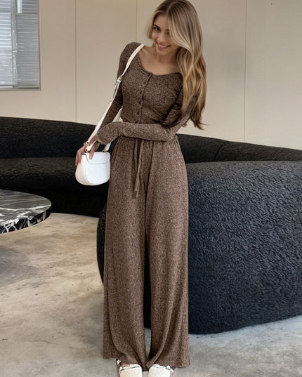 Woman wearing a brown outfit standing in a modern indoor setting.