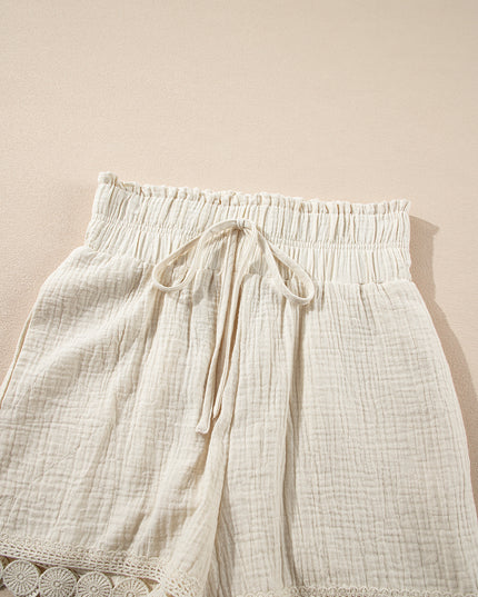White shorts with lace trim on a beige background