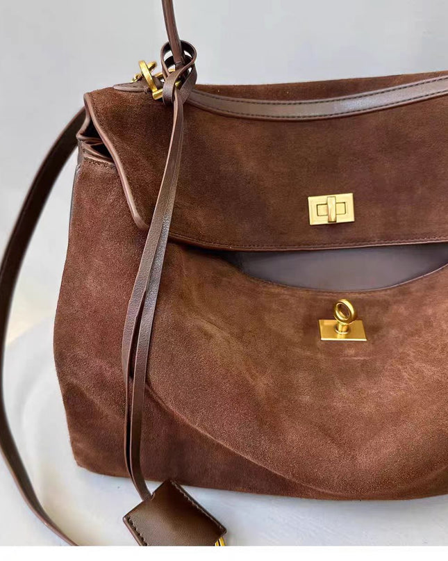 Brown leather handbag with gold hardware on a light background