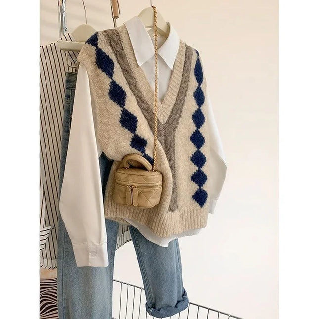 Beige sweater vest with blue diamond pattern over a white shirt and blue jeans, paired with a small brown handbag.