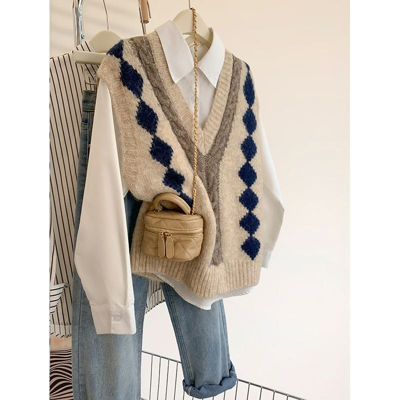 Beige sweater vest with blue diamond pattern over a white shirt and blue jeans, paired with a small brown handbag.