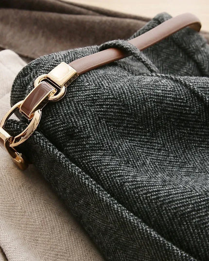 Close-up of a textured fabric with a gold and brown leather strap.