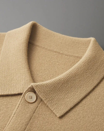 Close-up of a beige knit polo shirt collar with a button on a gray background