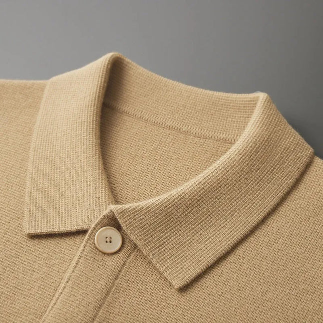 Close-up of a beige knit polo shirt collar with a button on a gray background