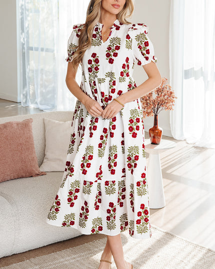 Woman wearing a white dress with red floral pattern in a living room.