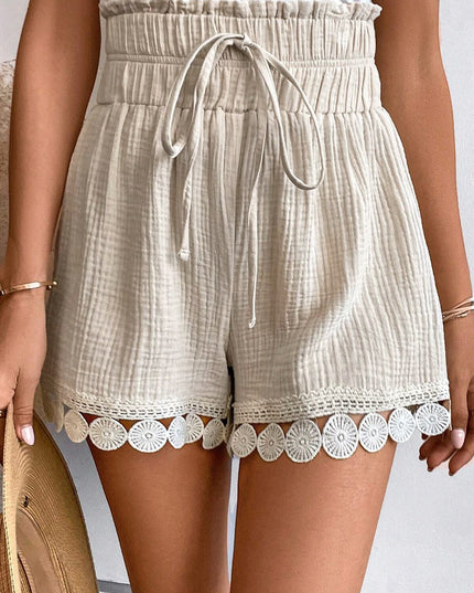 Beige shorts with lace trim worn by a person on a neutral background