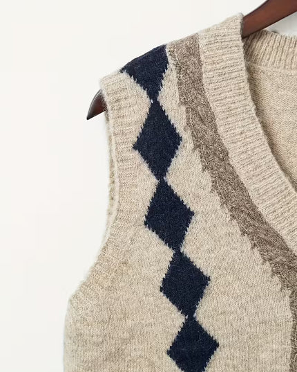 Beige sweater vest with diamond pattern on a hanger against a white background
