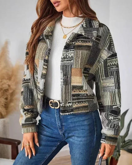 Woman wearing a patterned jacket and blue jeans indoors with decorative plants.