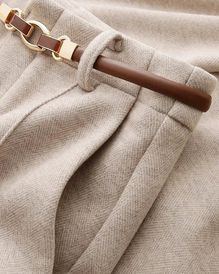 Close-up of beige fabric with a brown belt and gold buckle.