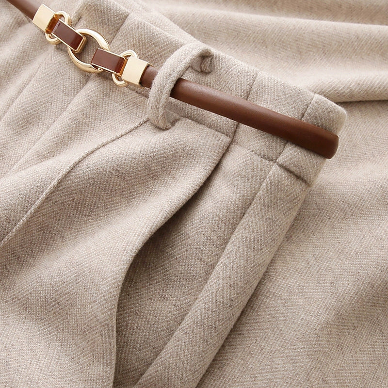 Close-up of beige fabric with a brown belt and gold buckle.