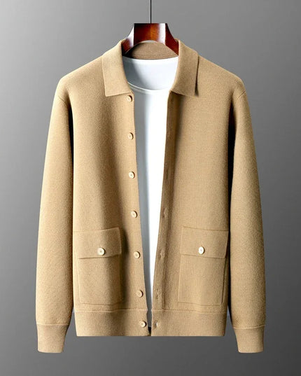 Beige cardigan on a hanger against a gray background