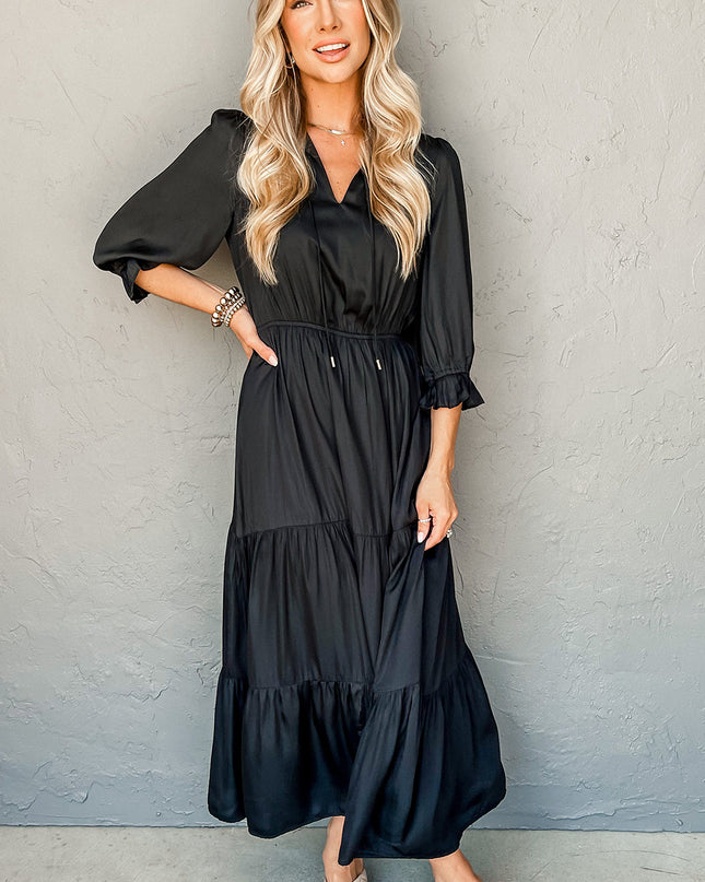 Woman wearing a black dress against a gray wall