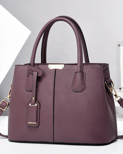 Purple handbag with gold accents on a white background