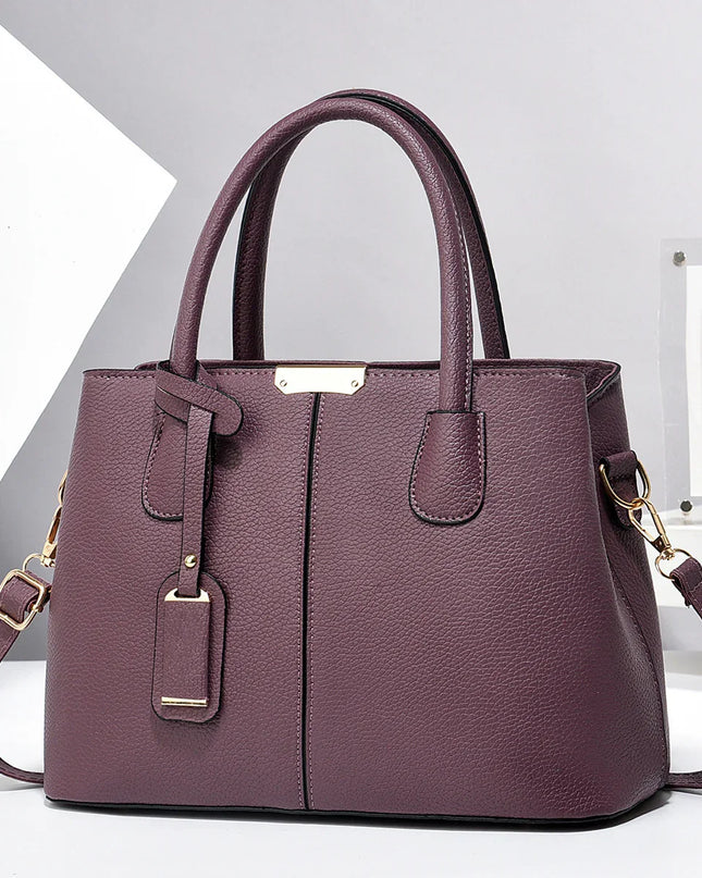 Purple handbag with gold accents on a white background