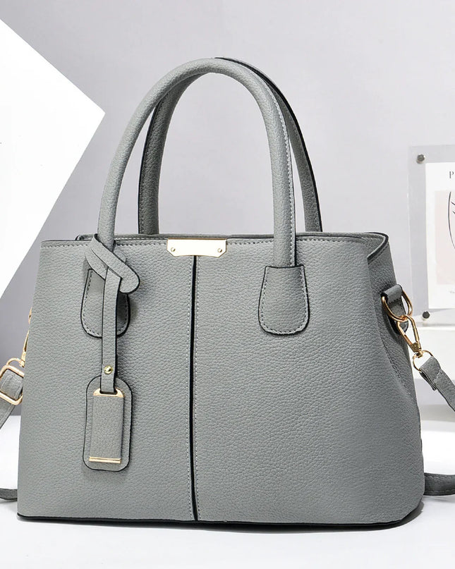 Gray handbag with gold accents on a white background