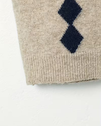 Beige knitted sweater with navy blue diamond pattern on a white background