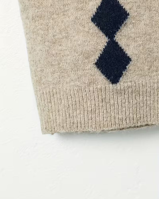 Beige knitted sweater with navy blue diamond pattern on a white background