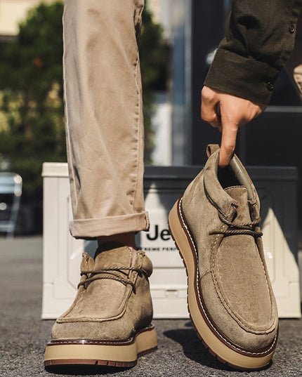 Person holding a brown shoe with a blurred background