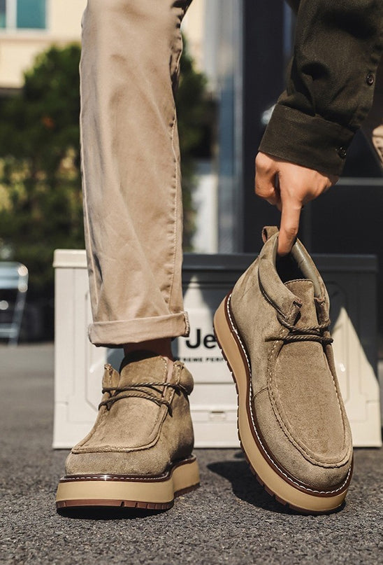 Person holding a brown shoe with a blurred background