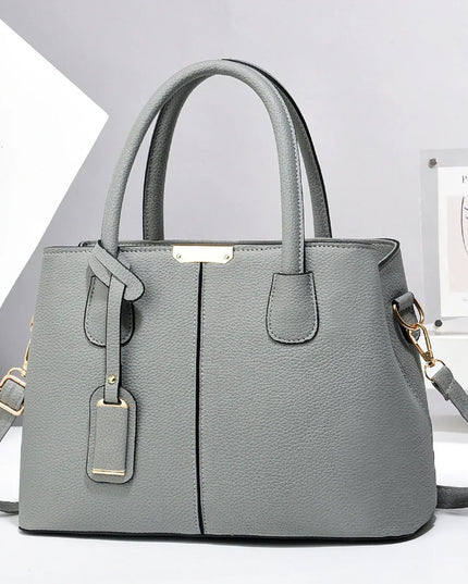 Gray handbag with gold accents on a white background