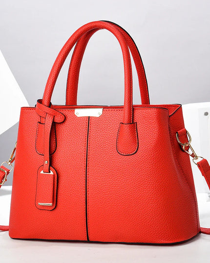 Red handbag with a strap on a light gray background