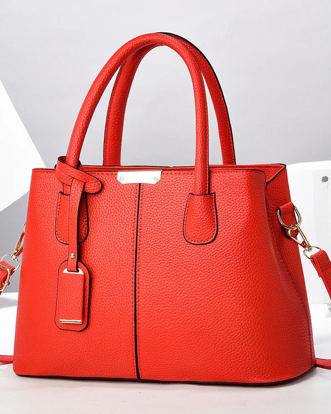 Red handbag with a strap on a light gray background