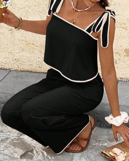 Woman wearing a black and white outfit with a textured wall background