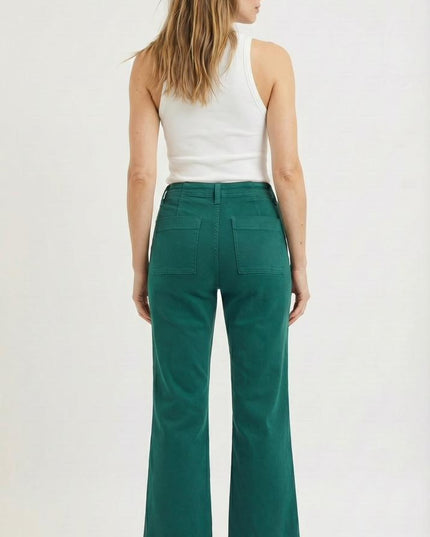 Woman wearing green pants and a white top on a white background