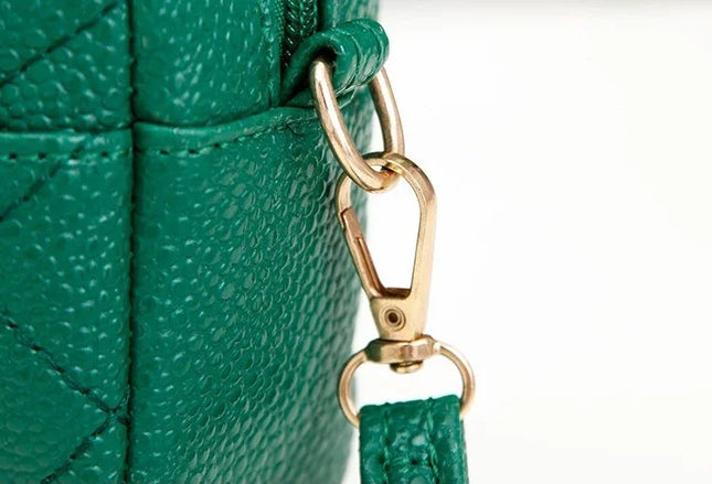 Close-up of a green handbag with a gold clasp on a white background